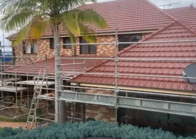 Tiled residential roof undergoing restoration work with scaffolding in place