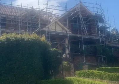Residential home surrounded by scaffolding during major roofing work