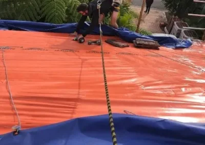Roofing team installing protective membrane during roof works