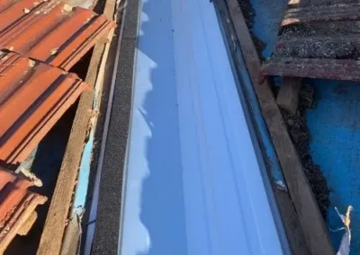 New metal valley flashing fitted between terracotta tiled roof sections