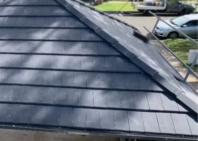 Restored dark grey tiled roof with renewed roof junctions