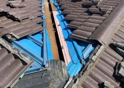 New blue valley flashing installed beneath dark roof tiles