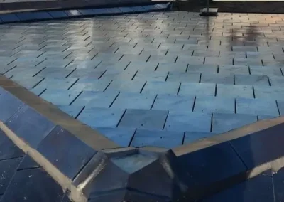 Dark roofing membrane installed across a low-pitch roof section