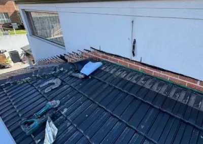 Metal roofing and flashing installed along an exterior wall junction
