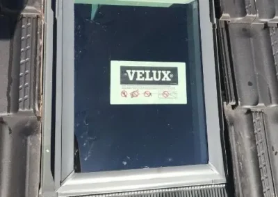 Velux roof window installed between roof tiles
