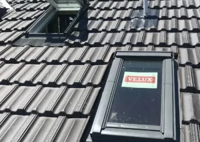 Roof window installed within a grey tiled roof