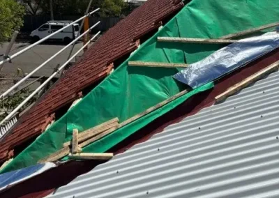 Residential roof replacement underway with roofing materials exposed