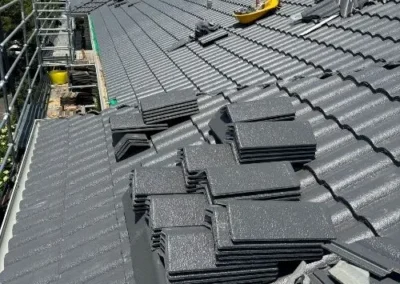 New grey roof tiles being installed during a roof replacement