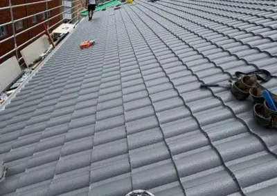 Grey tiled roof replacement underway on a residential property