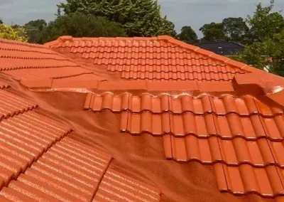 Completed terracotta tile roof restoration with a refreshed orange finish