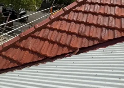 Terracotta tile roofing meeting a neighbouring metal roof