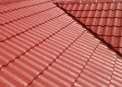 Restored tiled roof with an even red protective finish